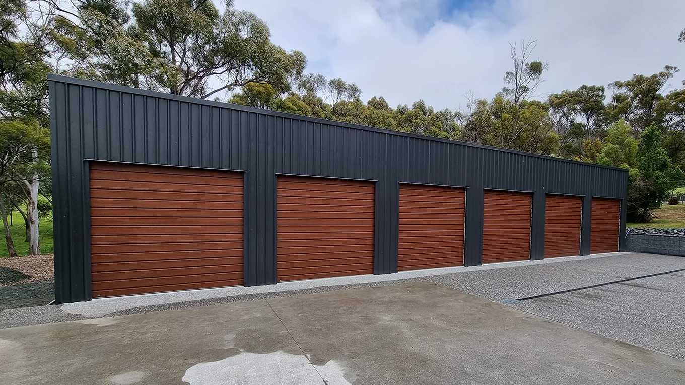 Six-bay garage with woodgrain roller doors in Monument.