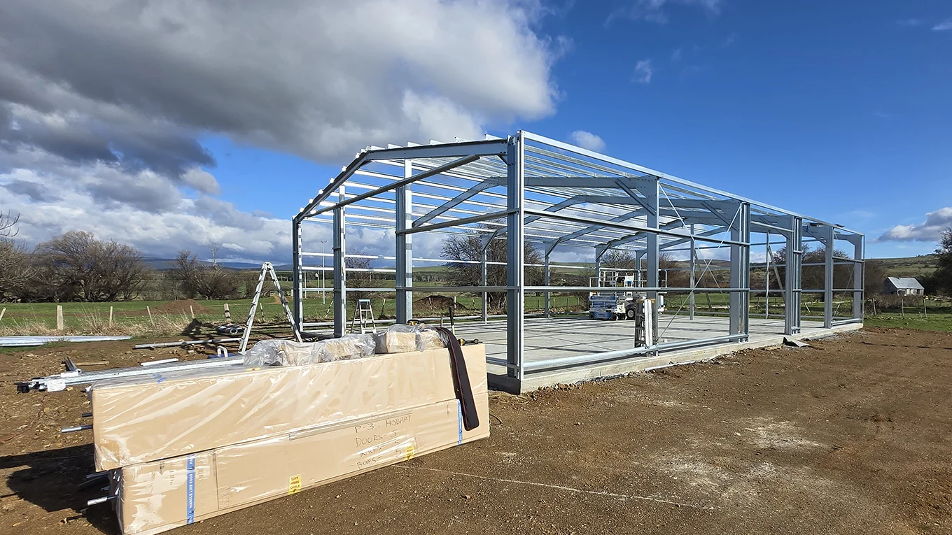 Steel frame construction for a ZINCALUME machinery shed.