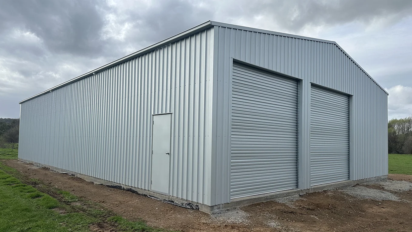 Farm shed with dual roller doors and personal access door.