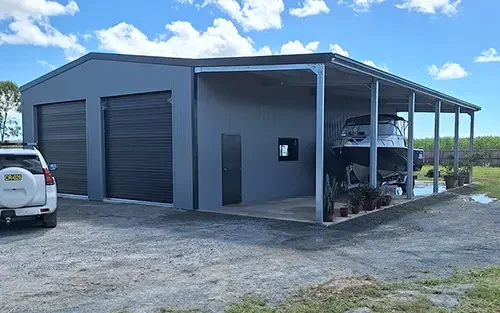 Photo of a Colorbond shed with an awning on the left hand side housing a boat.