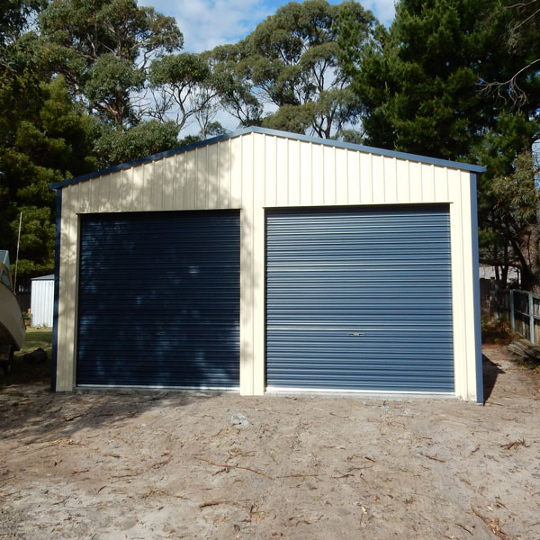 Car Garage clad in classic cream walls and deep ocean for the roller doors install in Canberra.