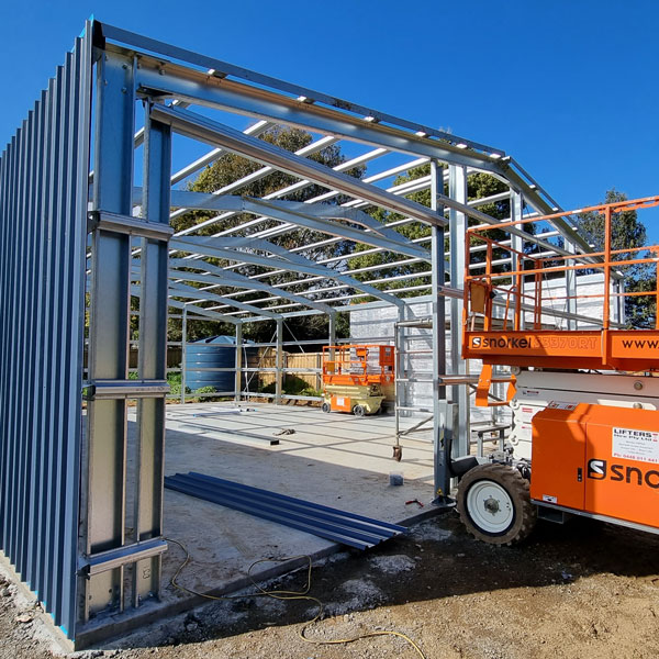 shed under construction with a scissor lift