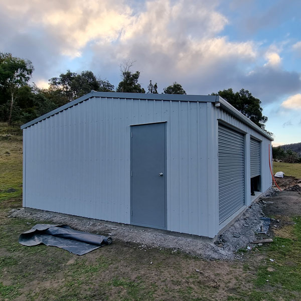 colorbond shed with 2 roller doors and 1 personal access door in windspray cladding