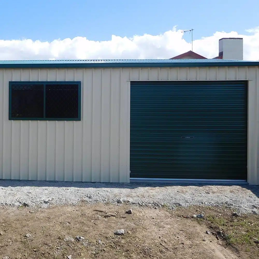 Cottage green sliding window in a classic cream shed.